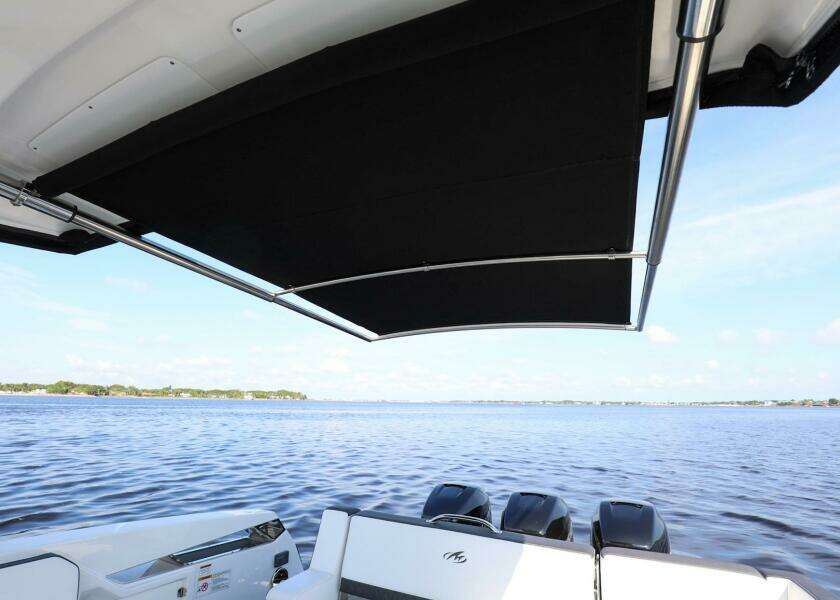 2023 Monterey 385 Super Sport boat with canopy, overlooking serene water.