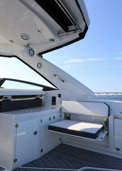 2023 Monterey 385 Super Sport yacht interior with seating and cabinetry, under a clear blue sky.