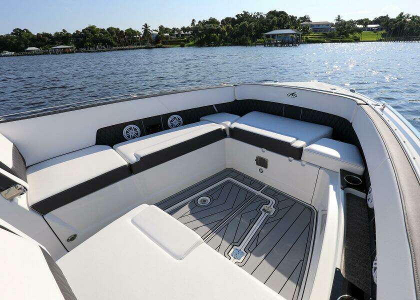 2023 Monterey 385 Super Sport boat interior with spacious seating, on a serene water backdrop.