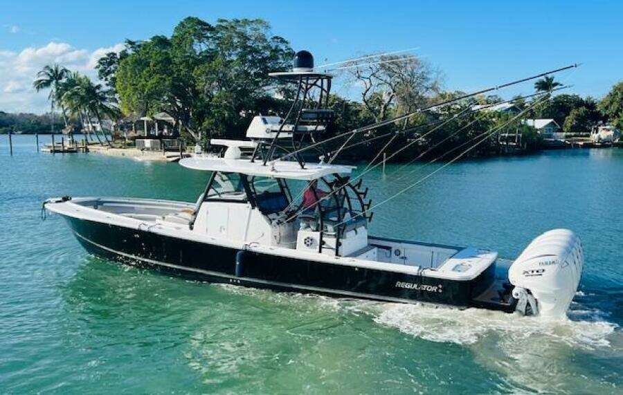 2024 Regulator 41 boat cruising in a scenic tropical waterway.