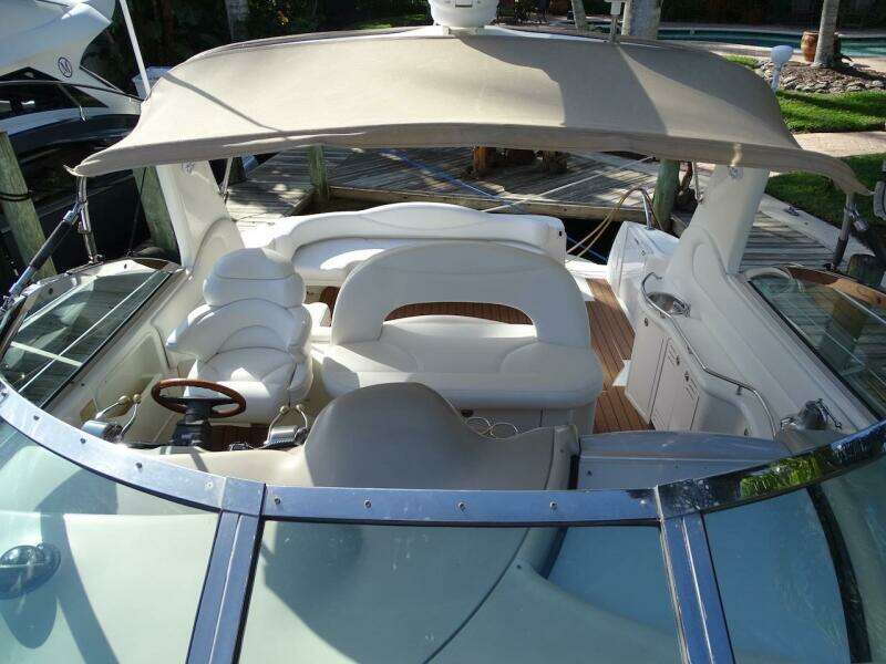2001 Sea Ray 410 Sundancer boat with spacious seating and canopy, docked at marina.
