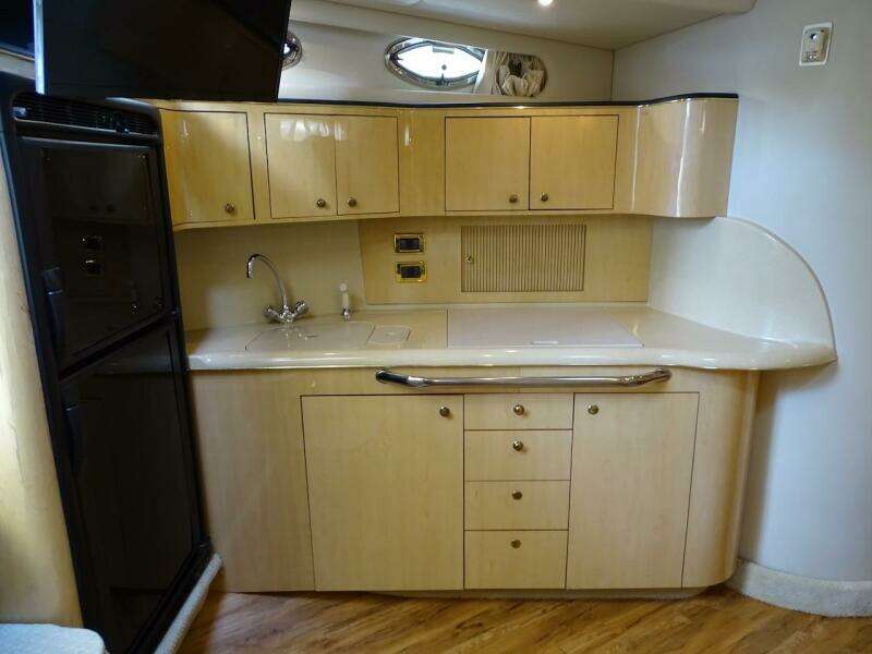 2001 Sea Ray 410 Sundancer kitchen with wooden cabinets and modern appliances.