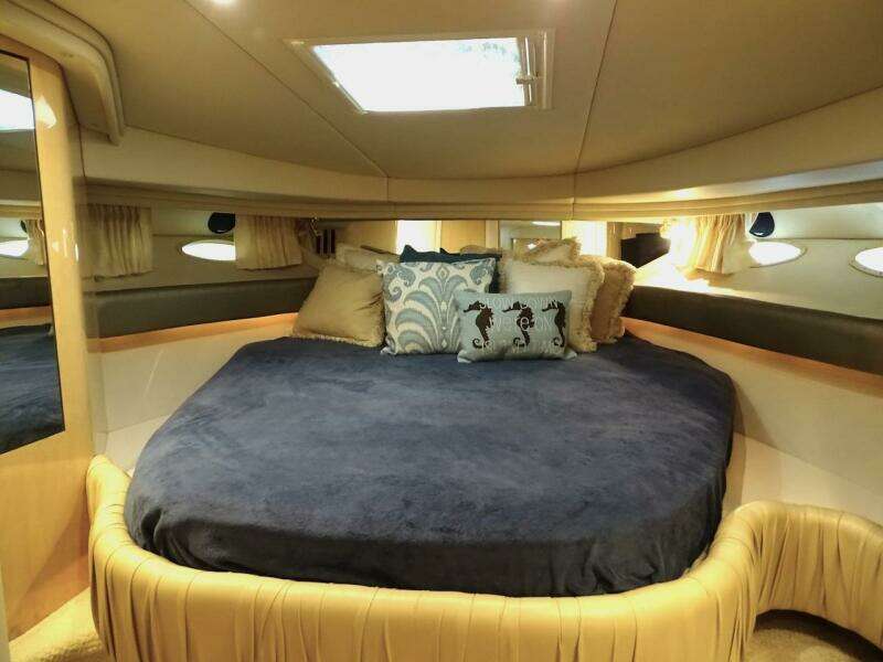 Luxurious cabin interior of 2001 Sea Ray 410 Sundancer yacht with plush bedding.