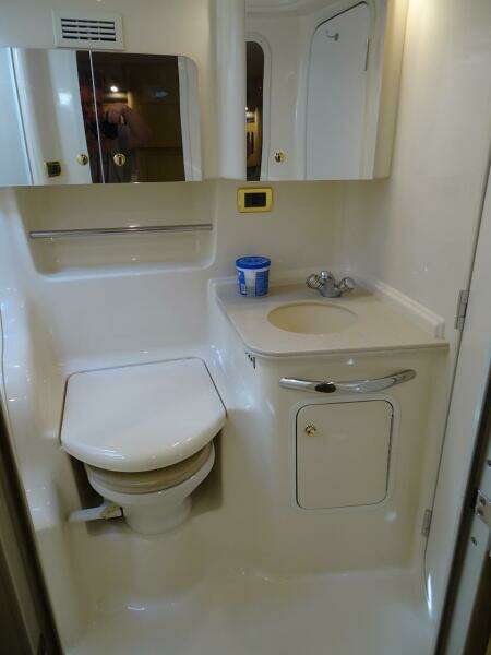 2001 Sea Ray 410 Sundancer bathroom with toilet, sink, and mirror.