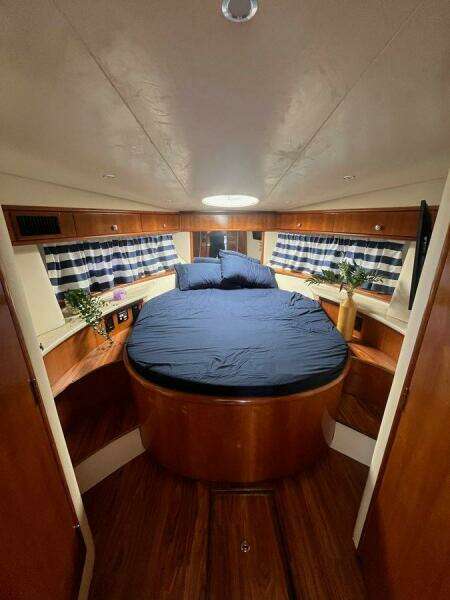 Interior of 2000 Carver 396 Motor Yacht with cozy bed and nautical decor.