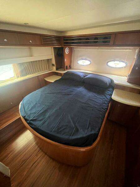 Interior cabin of 2000 Carver 396 Motor Yacht with bed and porthole windows.