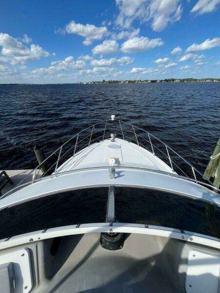 2000 Carver 396 Motor Yacht on open water under a blue sky with clouds.