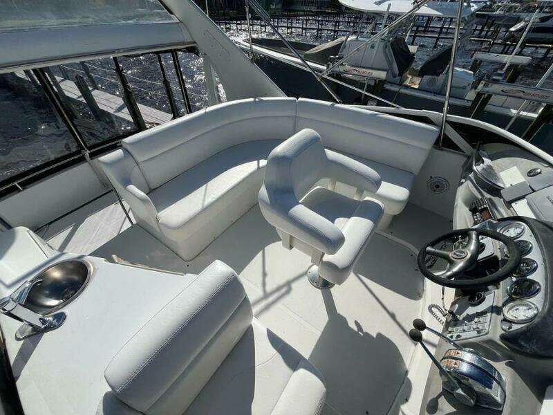 Spacious deck of 2000 Carver 396 Motor Yacht with white seating and control panel.