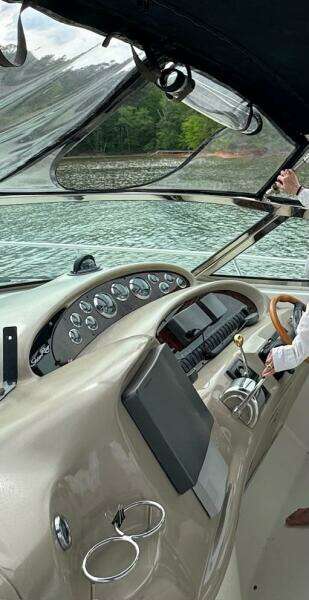 2001 Sea Ray 380 Sundancer helm with gauges, steering wheel, and water view.
