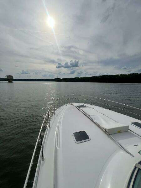 2001 Sea Ray 380 Sundancer cruising on a calm lake under a cloudy sky.