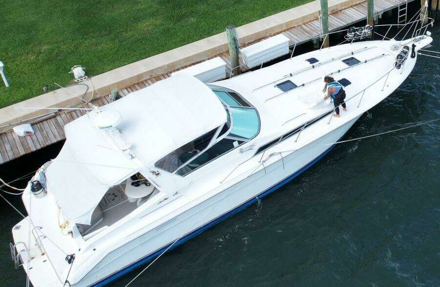 Aerial view of a 1993 Sea Ray 440 Sundancer yacht docked, with a person cleaning the deck.