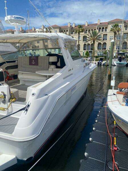 1993 Sea Ray 440 Sundancer docked at marina with luxury waterfront backdrop.