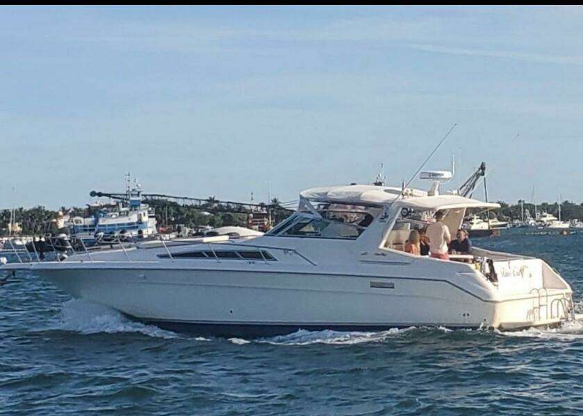 1993 Sea Ray 440 Sundancer yacht cruising on a sunny day with passengers onboard.