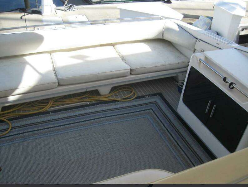 Interior seating area of a 1993 Sea Ray 440 Sundancer yacht with cushions and storage.