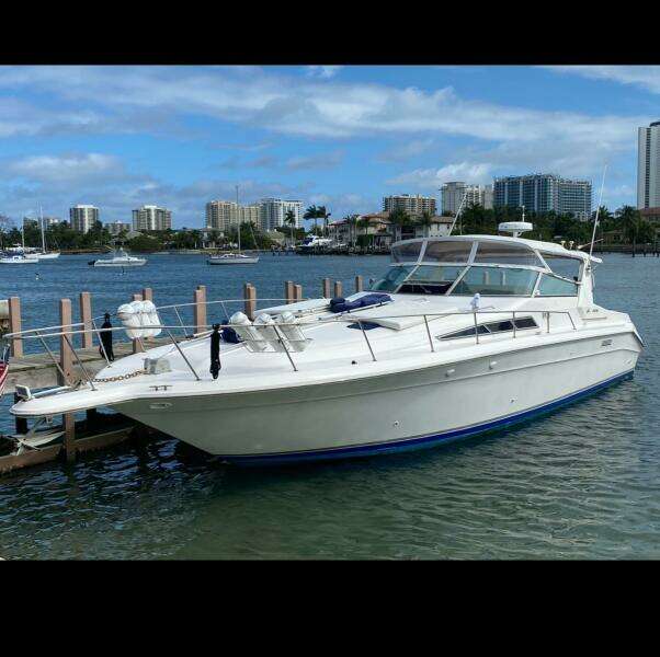 1993 Sea Ray 440 Sundancer yacht docked in a marina with city skyline.