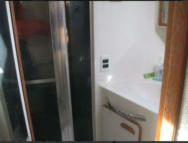 Bathroom interior of 1993 Sea Ray 440 Sundancer yacht, featuring sink and shower.