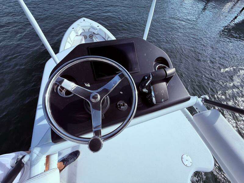 2024 Contender 39 ST boat helm with steering wheel and controls, overlooking water.