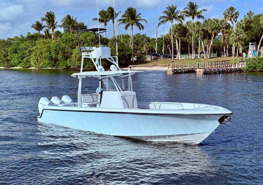 2024 Contender 39 ST boat on water, surrounded by palm trees and a dock.