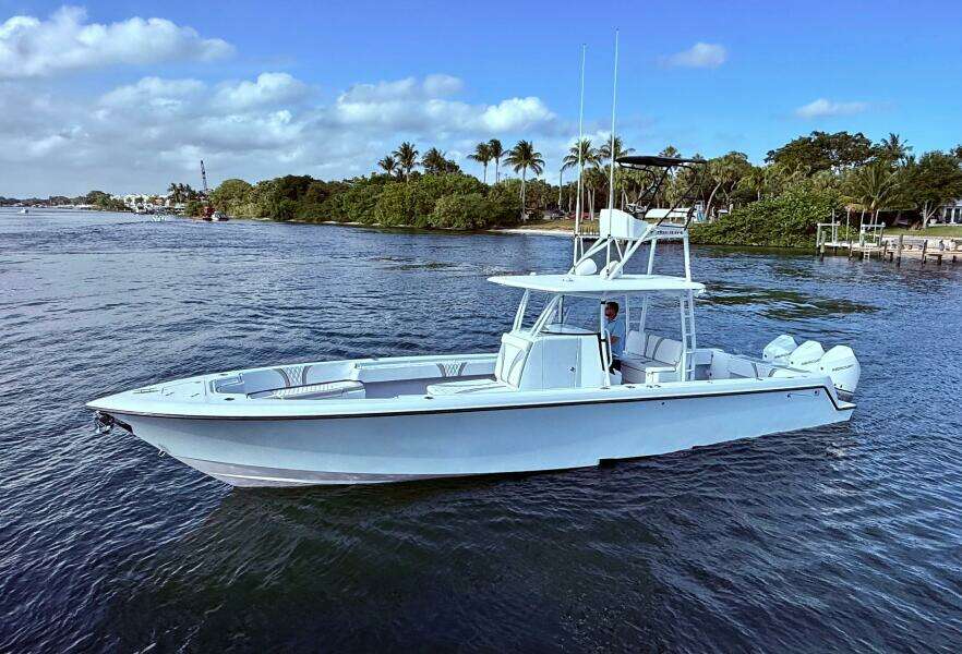 2024 Contender 39 ST boat on calm water with scenic background.