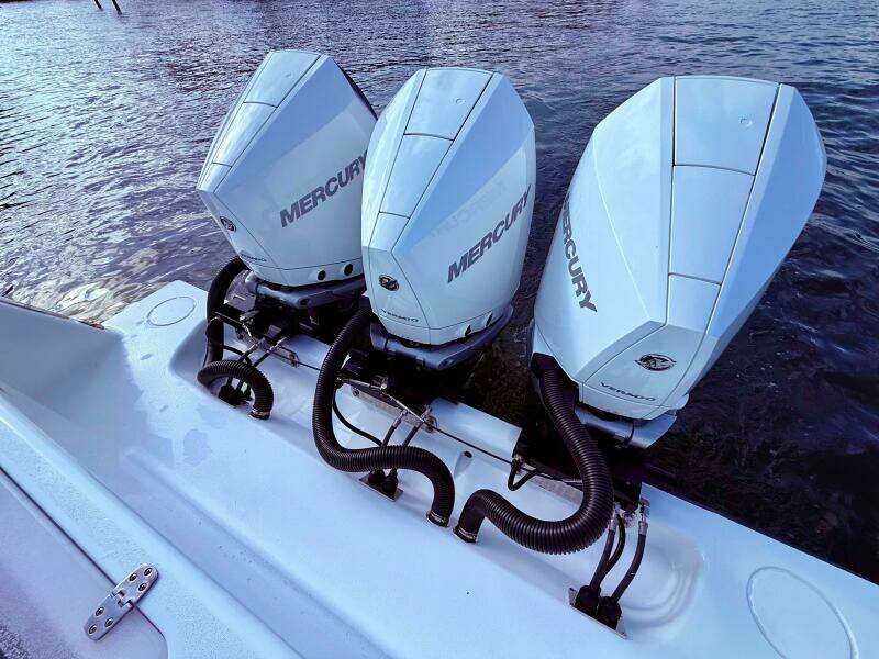 Triple Mercury outboard engines on 2024 Contender 39 ST boat, docked on water.