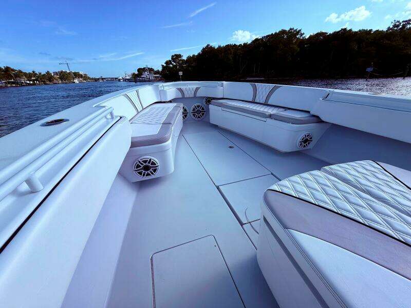 2024 Contender 39 ST boat interior with cushioned seating, on a calm waterway.