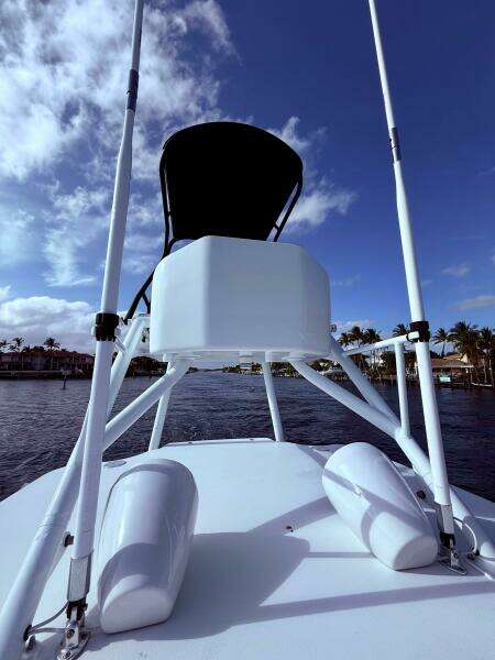 2024 Contender 39 ST boat with tower against a blue sky and waterfront view.