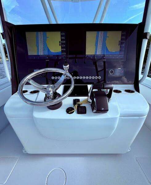 2024 Contender 39 ST boat dashboard with dual navigation screens and steering wheel.
