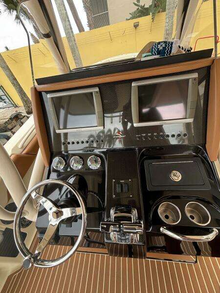 Control panel of a 2013 Statement 35 Center Console boat with dual screens and steering wheel.