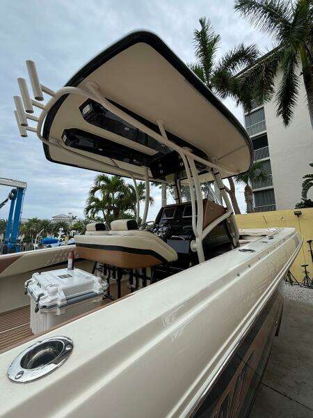 2013 Statement 35 Center Console boat with T-top, docked near palm trees.