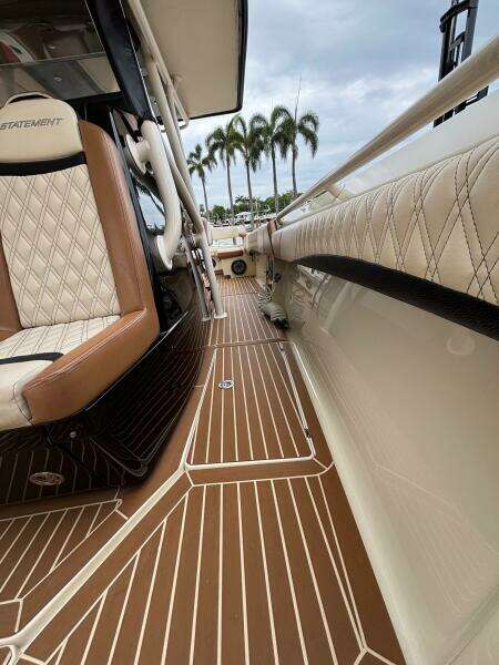 Luxurious 2013 Statement 35 Center Console boat interior with elegant seating and wood-patterned flooring.