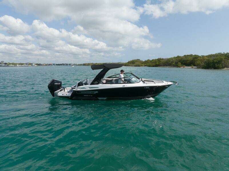 2023 Monterey 255 Super Sport boat cruising on clear blue water under a partly cloudy sky.