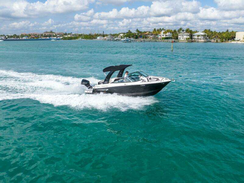 2023 Monterey 255 Super Sport boat cruising on turquoise water under a partly cloudy sky.