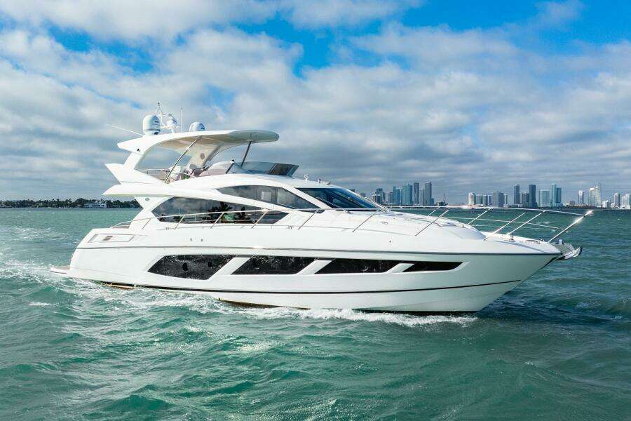 2016 Sunseeker Manhattan 65 yacht cruising on open water with city skyline backdrop.