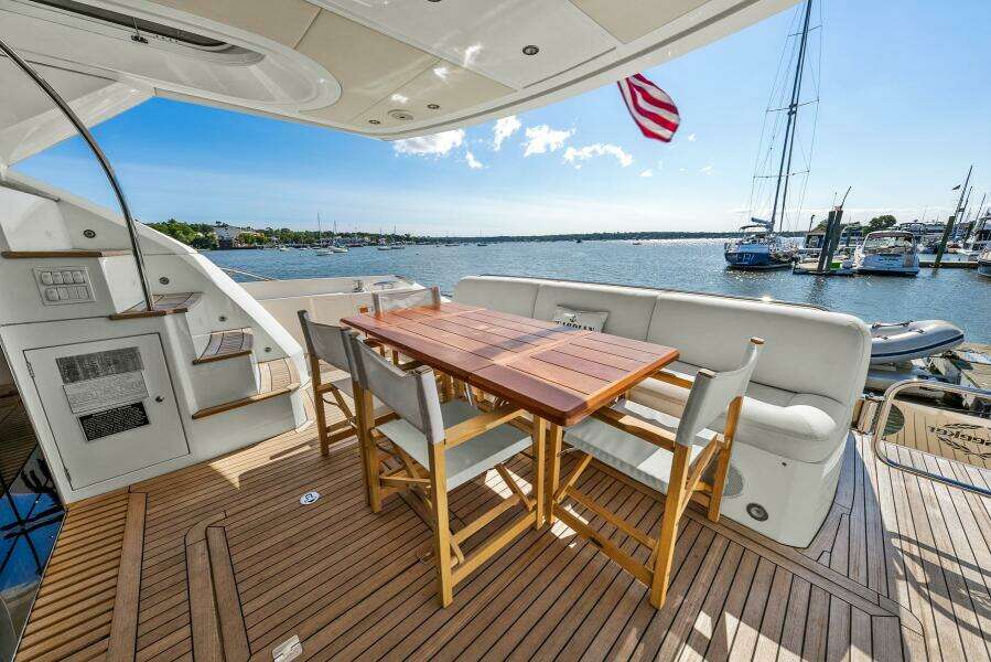 Luxurious Sunseeker Manhattan 65 yacht deck with dining area, overlooking marina, 2016 model.