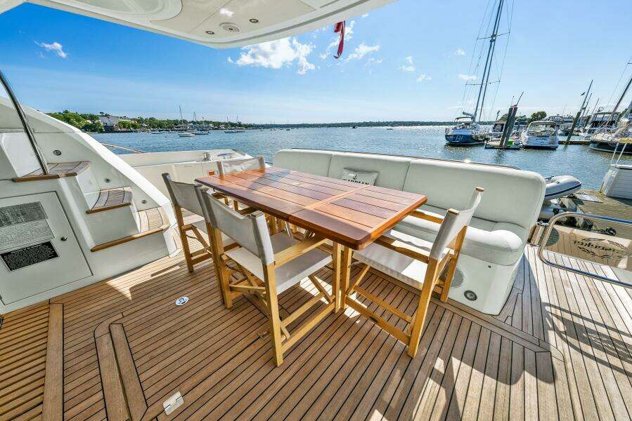 Luxury Sunseeker Manhattan 65 yacht deck with dining area, 2016 model, overlooking marina.