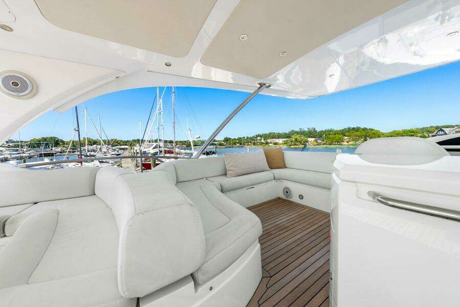 Luxurious 2016 Sunseeker Manhattan 65 yacht interior with white seating and wooden deck.