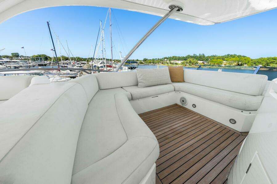 Luxurious seating area on 2016 Sunseeker Manhattan 65 yacht, docked at marina.