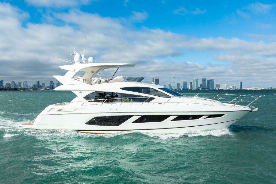 2016 Sunseeker Manhattan 65 yacht cruising on open water with city skyline backdrop.