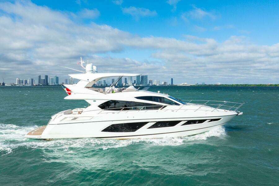 2016 Sunseeker Manhattan 65 yacht cruising on open water with city skyline backdrop.