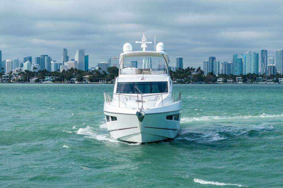 2016 Sunseeker Manhattan 65 yacht cruising with city skyline in the background.