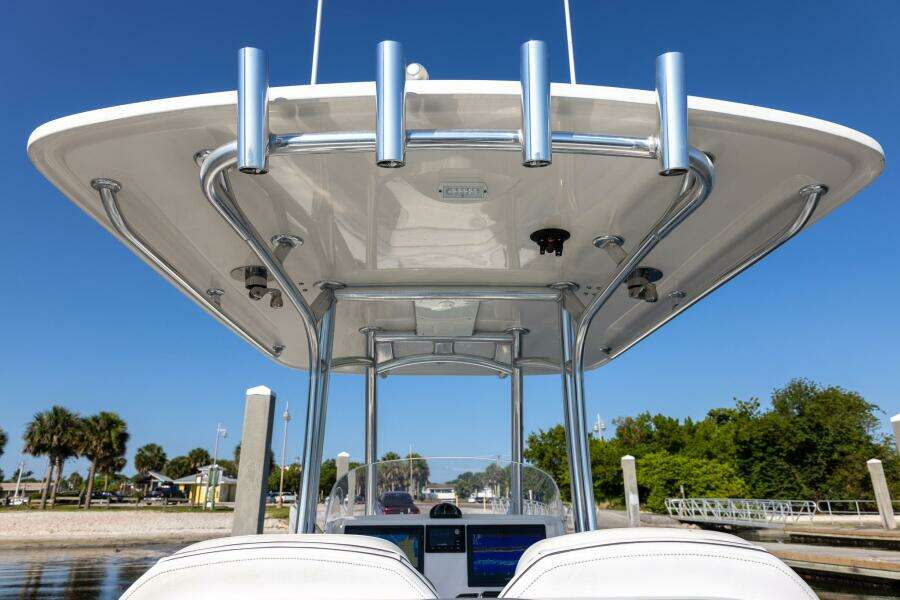 2018 Jupiter 26 FS boat with T-top and rod holders, docked under clear blue sky.
