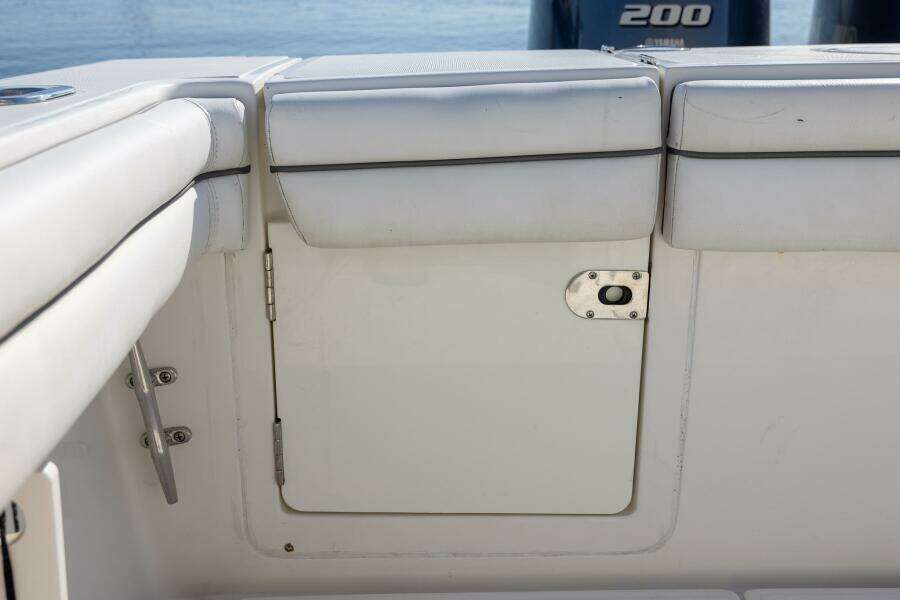 2018 Jupiter 26 FS boat interior with white cushioned seating and storage compartment.