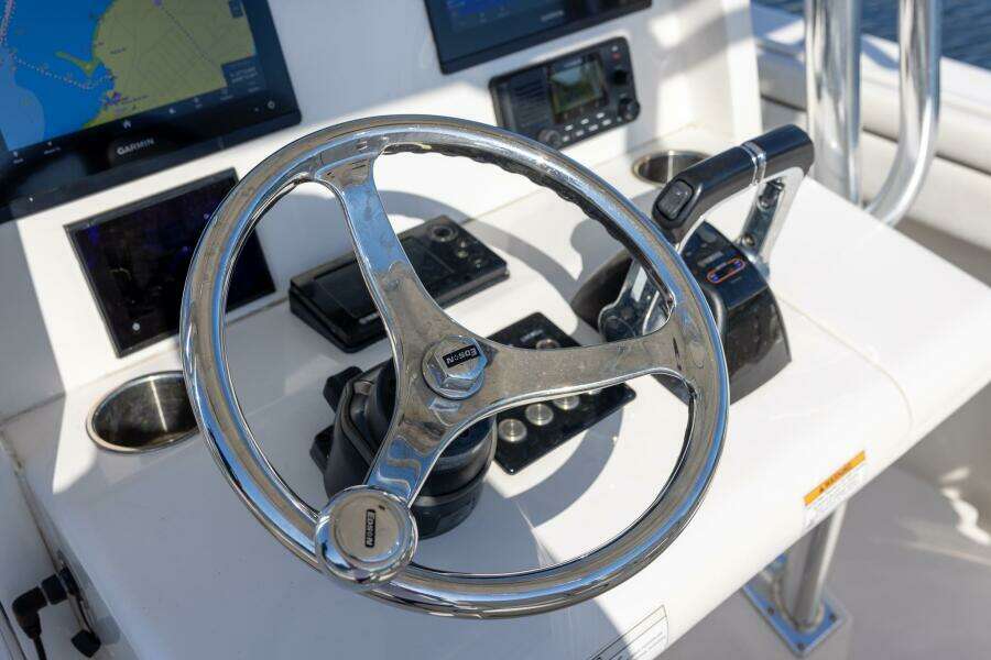 Steering wheel and controls of a 2018 Jupiter 26 FS boat cockpit.