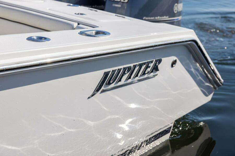 2018 Jupiter 26 FS boat, close-up of logo on sleek white hull.