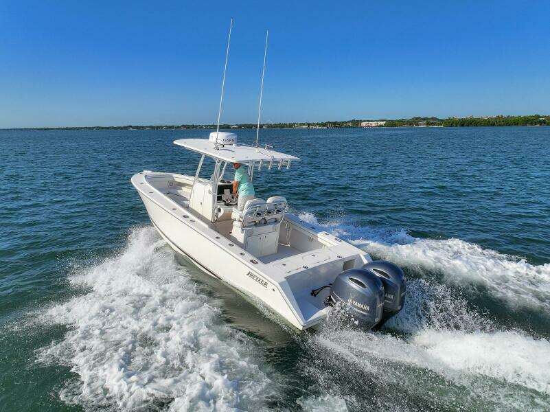 2018 Jupiter 26 FS boat cruising on open water with twin engines.