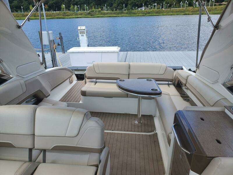 2015 Formula 330 Crossover Bowrider interior with seating and table, docked by a lake.