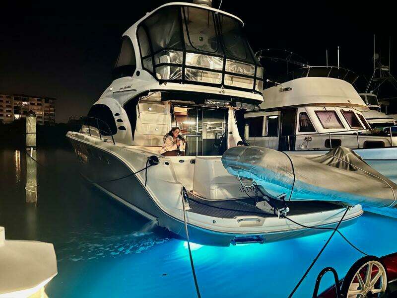 2005 Sea Ray 500 Sedan Bridge yacht docked at night with illuminated water.