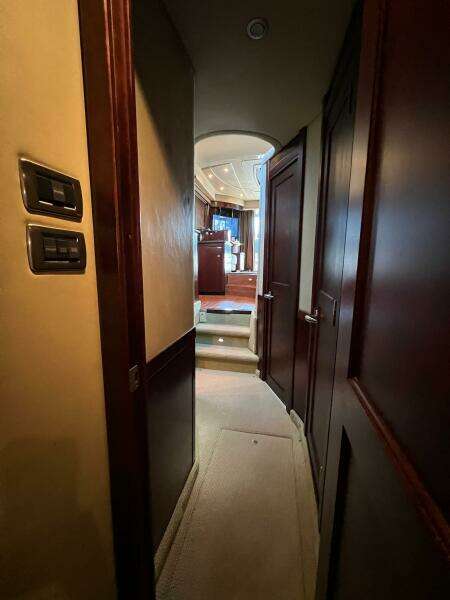 Hallway inside 2005 Sea Ray 500 Sedan Bridge yacht with wooden doors and carpeted floor.