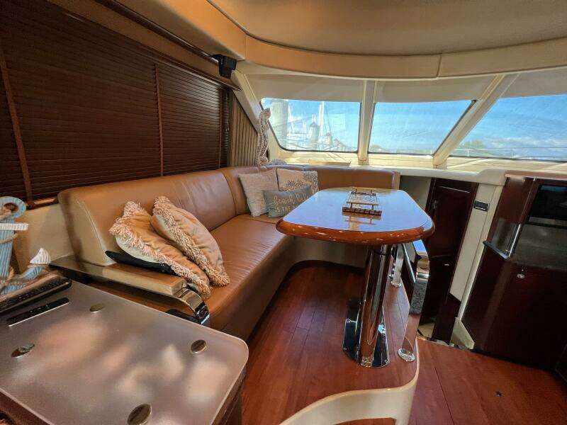 Luxurious interior of 2005 Sea Ray 500 Sedan Bridge yacht with plush seating and elegant table.