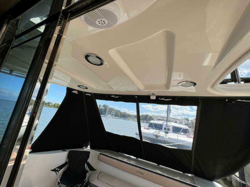 Interior view of a 2005 Sea Ray 500 Sedan Bridge yacht with black curtains and seating.